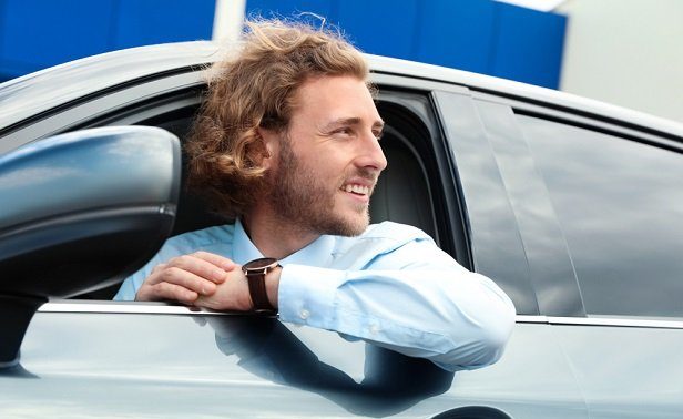 Man with his head coming out of an open car window