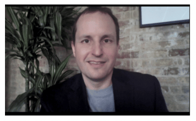 Man's headshot with brick background and a plant